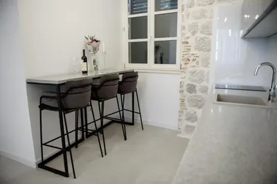 a kitchen with a bar with stools and a sink at Palazzo Sindik in Kotor