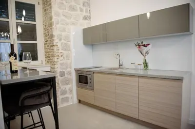 a kitchen with a sink and a counter with a table at Palazzo Sindik in Kotor