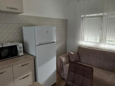 a kitchen with a white refrigerator and a couch at NEÐO Apartments Brda in Tivat