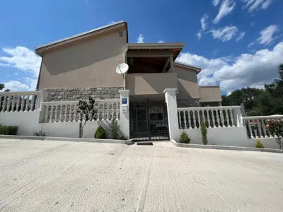 a house with a white fence and a driveway at NEÐO Apartments Brda in Tivat