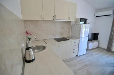 a kitchen with a sink and a white refrigerator at NEÐO Apartments Brda in Tivat