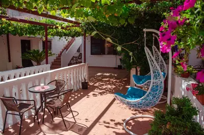 a patio with chairs and a table and some flowers at Mediterranean Retreat Becici in Becici
