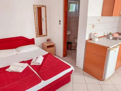 a bedroom with a red and white bed and a sink at Mediterranean Retreat Becici in Becici