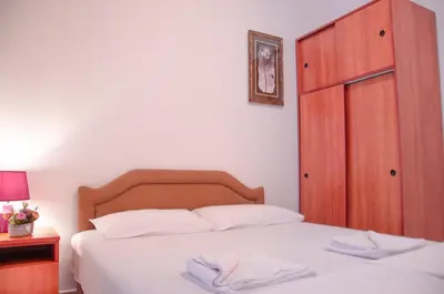a bedroom with a white bed and a wooden cabinet at Mediterranean Retreat Becici in Becici