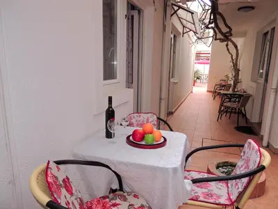 a table with a plate of fruit and a bottle of wine at Mediterranean Retreat Becici in Becici