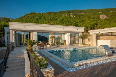 a house with a swimming pool in front of a house at Villa Salute in Budva