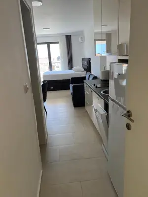 a room with a kitchen and a room with a bed at Apartments Petar in Budva