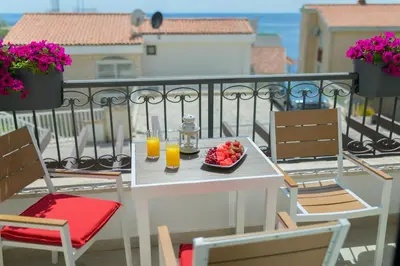 a table with a bowl of fruit and two glasses of orange juice at Apartments Petar in Budva