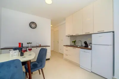 a kitchen with white appliances and a table and chairs at Apartments Petar in Budva