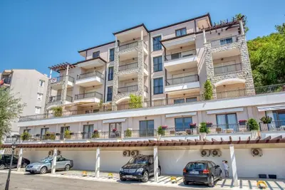 a large building with cars parked in front of it at Apartments Petar in Budva