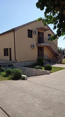 a large building with a staircase in front of it at Hostel Vera - Airport Podgorica in Podgorica
