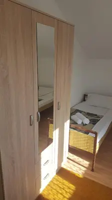 a bedroom with a bed and a door with a mirror at Hostel Vera - Airport Podgorica in Podgorica