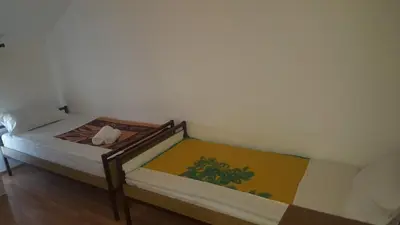 two twin beds in a room with at Hostel Vera - Airport Podgorica in Podgorica
