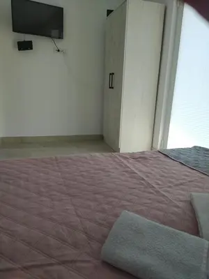 a bedroom with a bed and a tv on the wall at Hostel Vera - Airport Podgorica in Podgorica