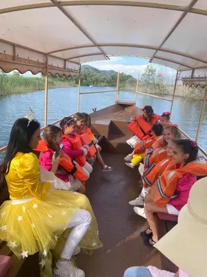 a group of children sitting on a boat on the water at Apartments Monte Green in Virpazar
