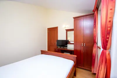 a bedroom with a bed and a cabinet and a television at Apartmani Becici in Becici