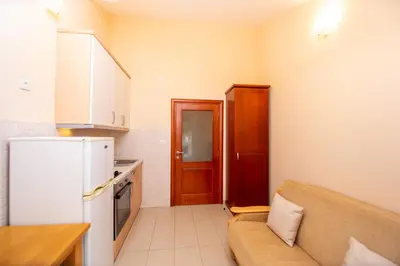 a small kitchen with a couch and a refrigerator at Apartmani Becici in Becici