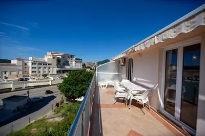 a balcony with a table and chairs on it at Apartmani Becici in Becici