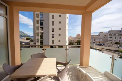 a balcony with a table and chairs and a view of a city at Apartmani Becici in Becici