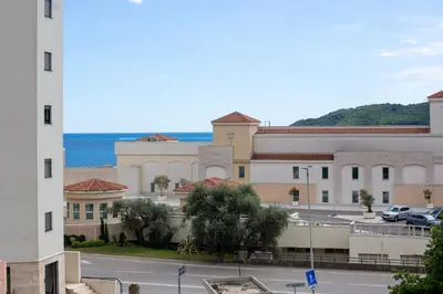 a view of a building with the ocean in the background at Apartmani Becici in Becici