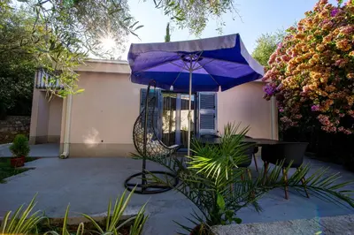 a purple umbrella sitting next to a chair and a table at Villa M&M in Budva