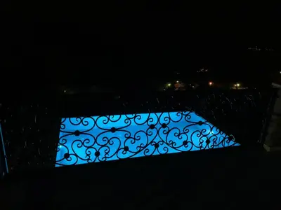 a fence with a blue light in the dark at Villa WOLF in Budva