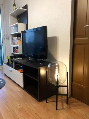 a living room with a television and a chair with a candle at Casa Alea in Ulcinj