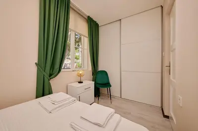 a bedroom with a bed and a green curtain at Mediterranean vacation home with pool Petrovac in Budva