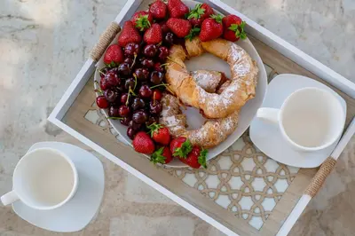 a tray with strawberries and pretzels on a table with two cups at Mediterranean vacation home with pool Petrovac in Budva