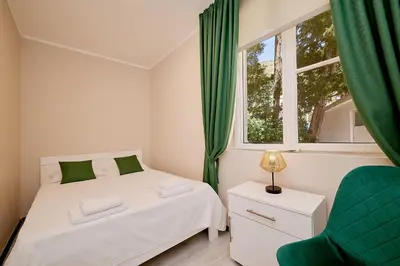 a bedroom with a bed and a window and a chair at Mediterranean vacation home with pool Petrovac in Budva