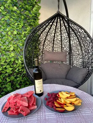 a table with two plates of fruit and a bottle of wine at Down Town Studio in Ulcinj