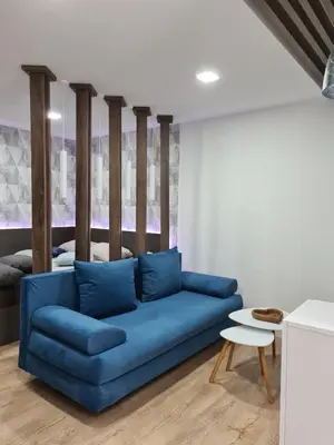 a living room with a blue couch and a table at Down Town Studio in Ulcinj