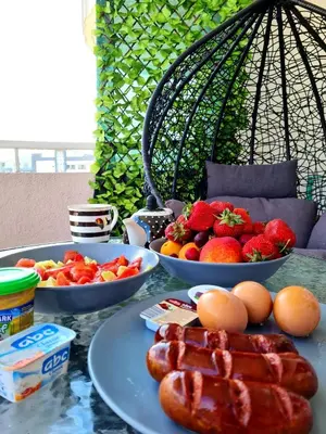 a table with two plates of food and bowls of fruit at Down Town Studio in Ulcinj