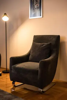 a chair sitting in a room with a lamp at Apartment Podgorica in Podgorica
