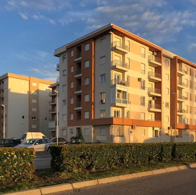 an apartment building with cars parked in front of it at Apartment Podgorica in Podgorica