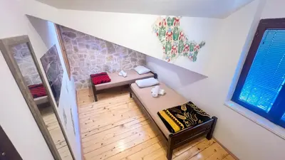 an attic room with a bed and a staircase at Old Town Homestel in Kotor