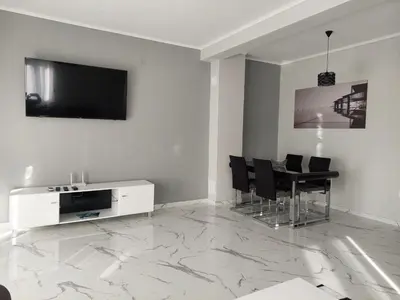 a living room with a television and a table with chairs at Adriatic Oasis in Bar