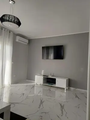 a living room with a television and a marble floor at Adriatic Oasis in Bar