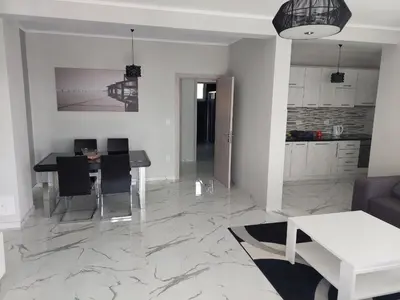 a living room with a table and a kitchen at Adriatic Oasis in Bar