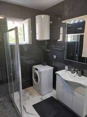 a bathroom with a washing machine and a sink at Adriatic Oasis in Bar