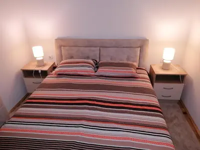 a bedroom with a large bed with two lamps on night stands at Marina in Budva