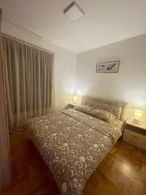 a bedroom with a bed and a window with two lamps at Marina in Budva