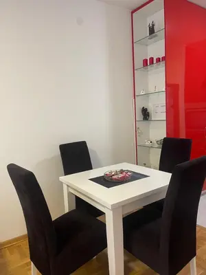 a dining room with a white table and black chairs at Marina in Budva