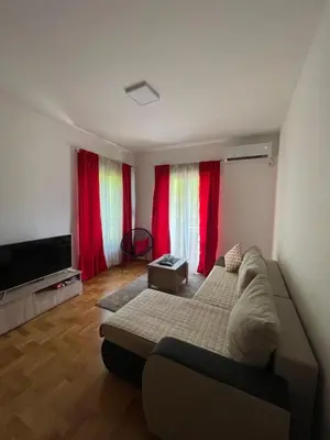 a living room with a couch and red curtains at Marina in Budva
