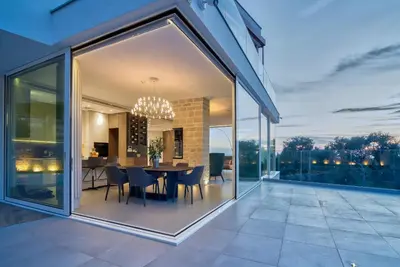 a glass extension of a house with a table and chairs at Villa Solaria in Sveti Stefan