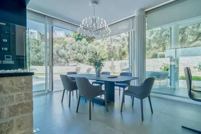 a dining room with a blue table and chairs at Villa Solaria in Sveti Stefan