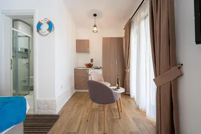a small living room with a table and a chair at Sunset & Sunrise Villas in Stanisici-Two Villas With Common Pool in Budva