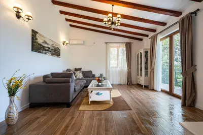 a living room with a couch and a table at Sunset & Sunrise Villas in Stanisici-Two Villas With Common Pool in Budva