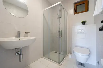 a bathroom with a shower and a sink and a toilet at Sunset & Sunrise Villas in Stanisici-Two Villas With Common Pool in Budva