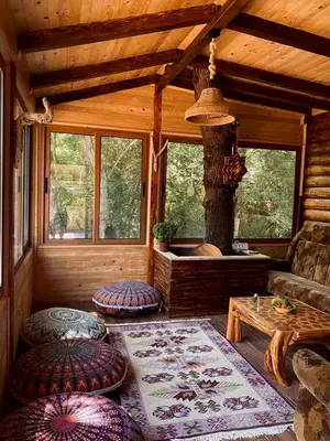 a living room with a fireplace in a log cabin at Sojenica Pustolov - Ada Bojana in Ulcinj